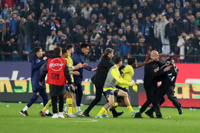 Fenerbache players are attacked by a Tranzonspor fan