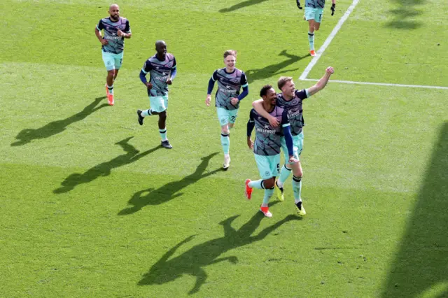 Brentford players celebrate their third goal.