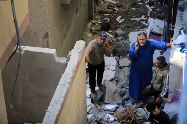 Palestinians inspect the destruction of a destroyed building following the Israeli attacks on Tel Al-Sultan neighborhood in Rafah, Gaza