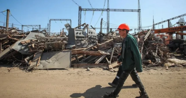 Workers walking passed destroyed power plant