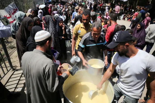 Displaced Palestinians are receiving cooked food rations at a donation point in Deir al-Balah in the central Gaza Strip,