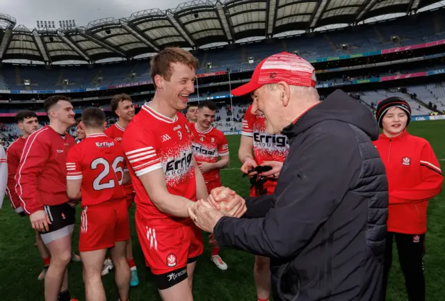 Derry midfielder Brendan Rogers and Mickey Harte celebrate winning the First Division title at Croke Park