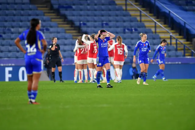 Leicester player stand stunned after another Arsenal goal.