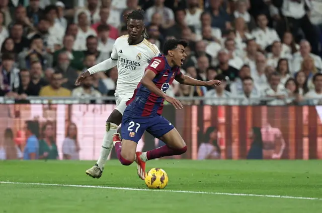 Lamine Yamal (R) is tackled by Real Madrid's French midfielder Eduardo Camavinga