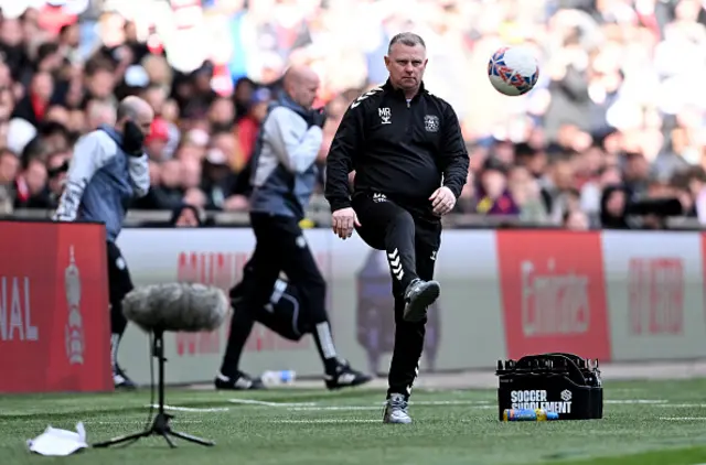 Mark Robins, Manager of Coventry City, passes the ball