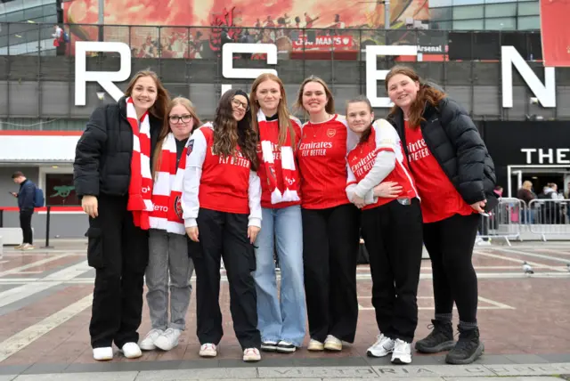 Arsenal fans poise outside the emirates ahead of going inside