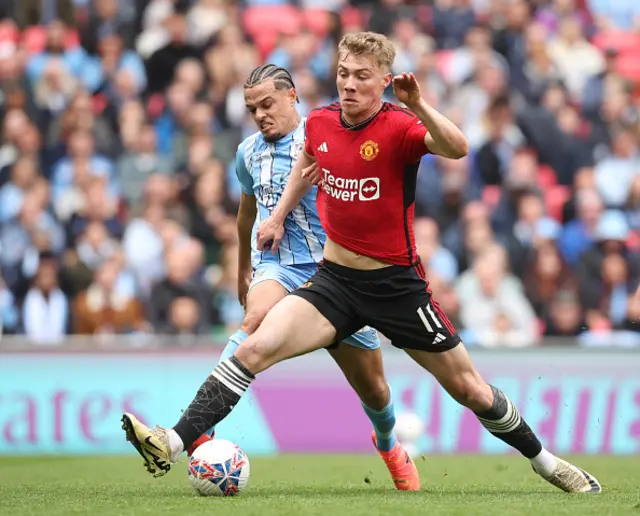 Joel Latibeaudiere of Coventry City and Rasmus Hojlund of Manchester United challenge