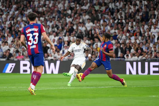 Vinicius Junior of Real Madrid takes a shot whilst under pressure from Jules Kounde