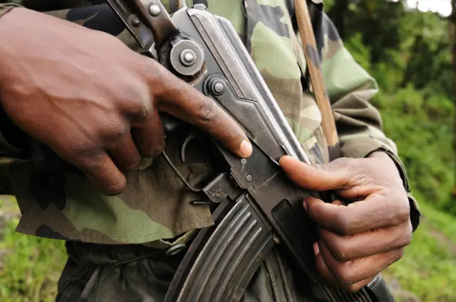 An anonymous soldier holds a semi-automatic assault rifle. Stock image.