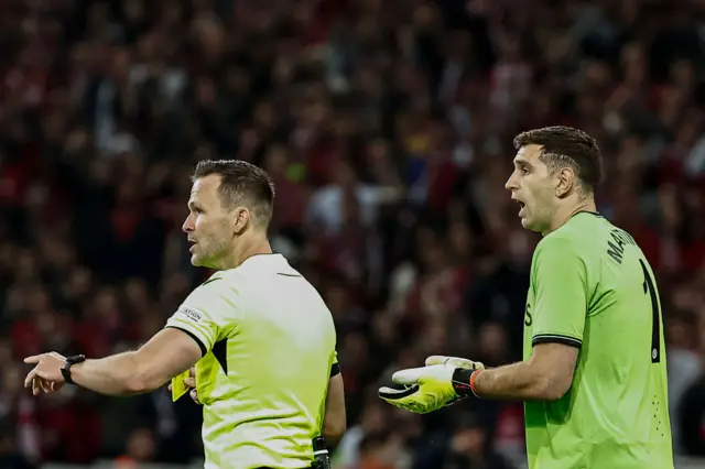 Emi Martinez is shown a yellow card during Aston Villa's victory over Lille