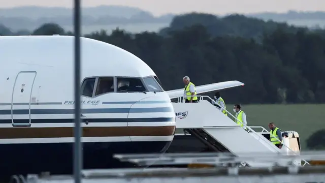 Members of the staff board a plane at MOD Boscombe Down base in Wiltshire, Britain, June 14, 2022.