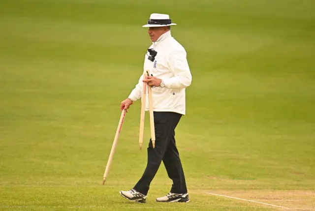 Umpire Russell Warren removes the stumps