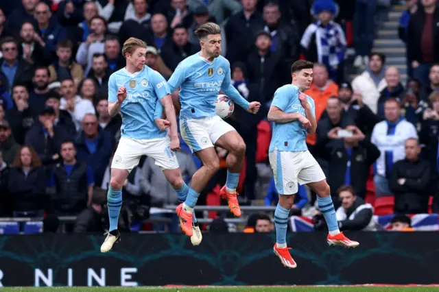 Jack Grealish jumps as part of Manchester City wall