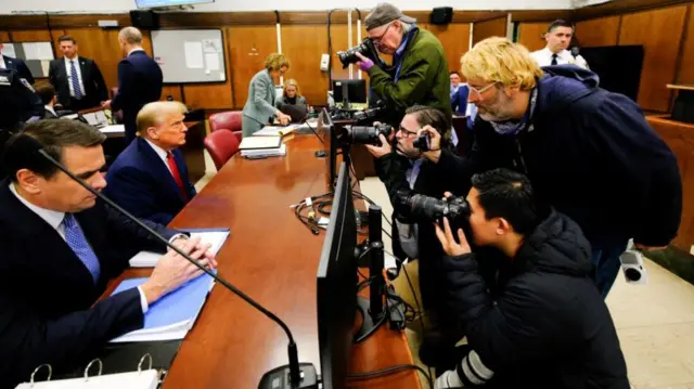 Photographers in front of Donald Trump