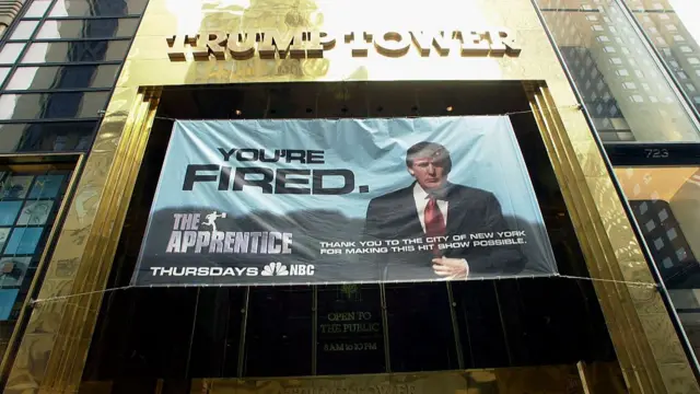 A banner promoting the hit television show "The Apprentice" hangs from the entrance of Trump Tower on March 19, 2004. The expression "You're Fired" is Trump's signature line in the show and Trump has expressed plans to trademark the expression for marketing purposes.