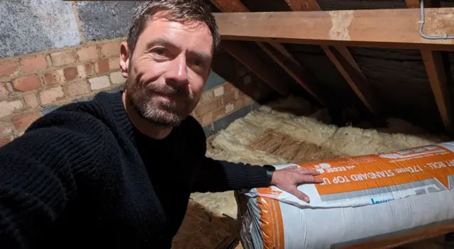 Allen Sinclair fitting insulation in his loft