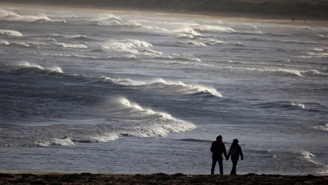 People walk along the beach near Redcar