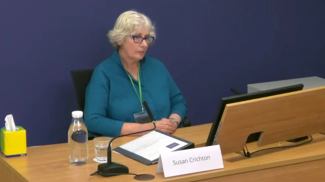 Susan Crichton looking sad sitting at a desk