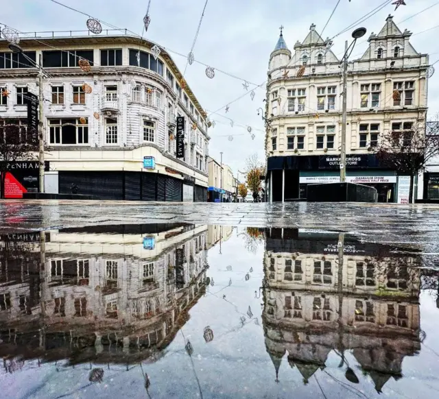 Middlesbrough high street reflected in a puddle