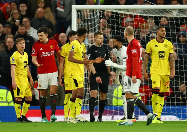 Utd players protest and ask for a penalty