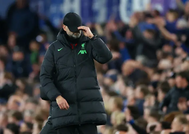 Klopp pulls his cap over his face