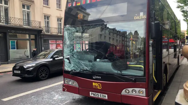 Damaged windscreen of a red London tour bus following a runaway horse's collision with it