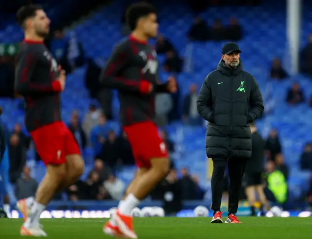 Jurgen Kloppw watches his Liverpool players warm up