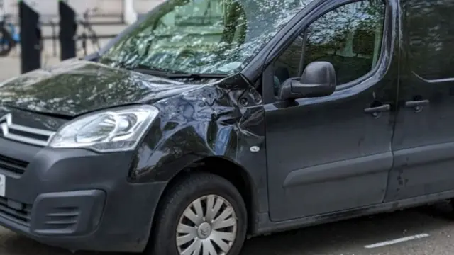 A damaged small van with a dint above its right wheel following a horse's escape through London