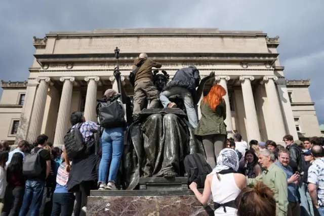 People climbing a statue