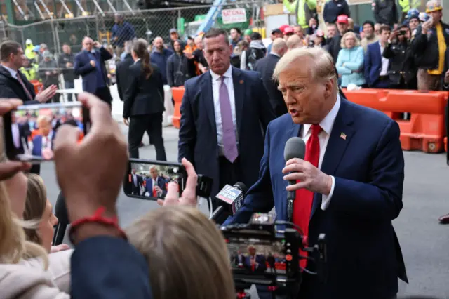 Donald Trump speaks with members of the press