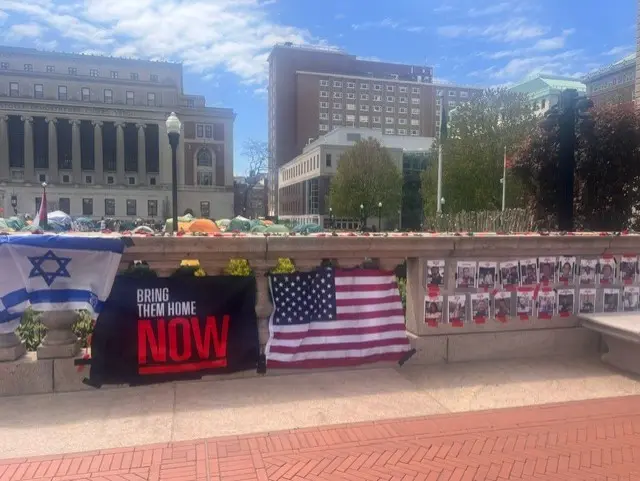 An Israeli flag, a slogan saying "bring them home now" and the American flag