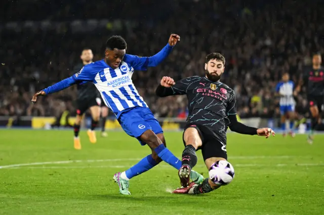 Simon Adingra of Brighton & Hove Albion is tackled by Josko Gvardiol of Manchester City