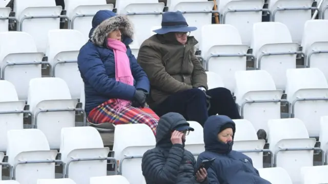 Cricket spectators warmly clad