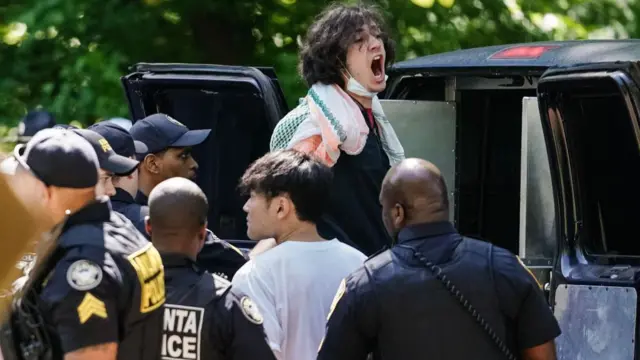 A protester is put in the back of a police van