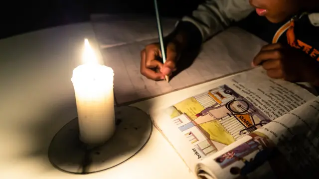 A boy studying by candlelight