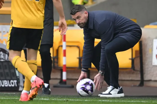 Rob Edwards retrieves the ball for Luton