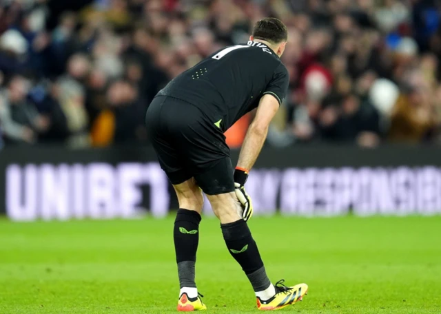 Aston Villa goalkeeper Emiliano Martinez stretches his hamspring