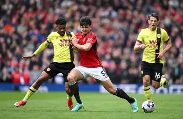 Lyle Foster of Burnley is challenged by Harry Maguire