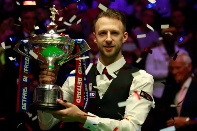 Judd Trump holding the World Championship trophy