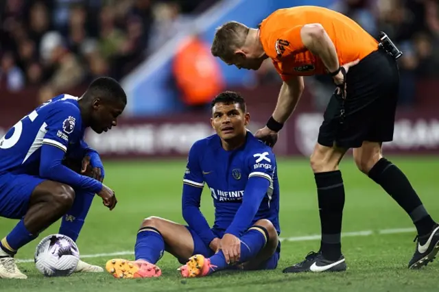 Thiago Silva (C) holds his ankle as he sits injured