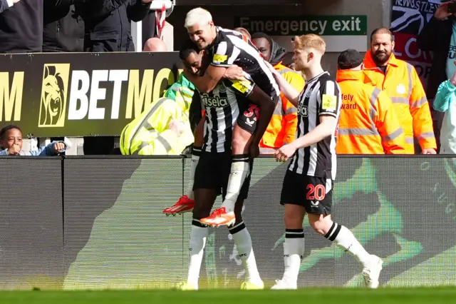 Guimaraes jumps on Isak's shoulders after the Swede's second goal