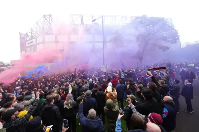 Villa fans welcome the team bus to the stadium with flares