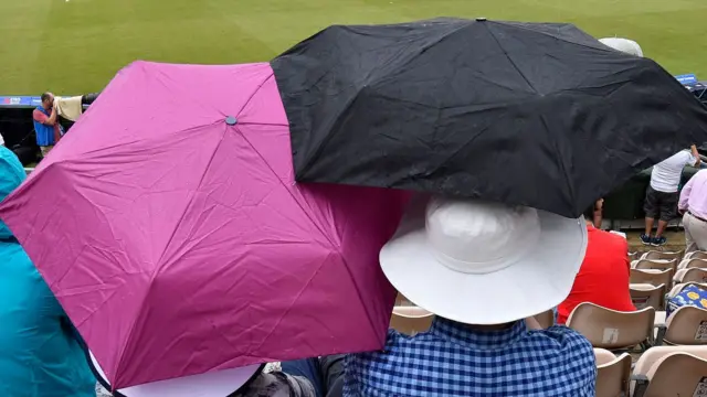 Umbrellas up at the cricket