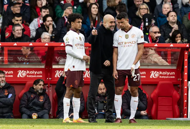 Manchester City's manager Pep Guardiola (centre) briefs substitutes Oscar Bobb (left) and Matheus Nunes