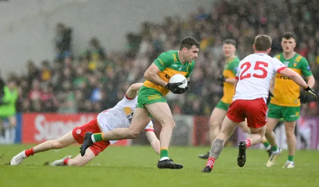 Donegal's Caolan McGonagle escapes the challenge of Tyrone forward Cathal McShane