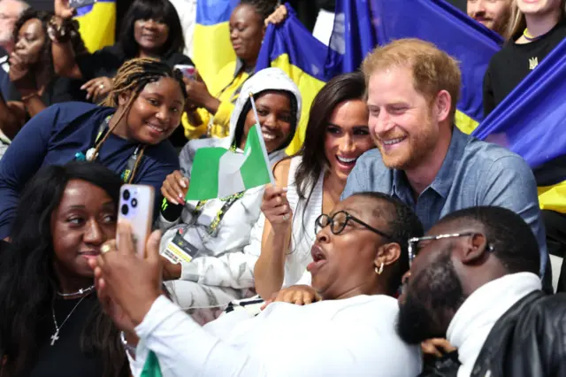 Meghan, Duchess of Sussex Prince, and Prince Harry, Duke of Sussex, take selfies with fans as they attend the Ukraine Nigeria Mixed Team Preliminary Round - Pool A Sitting Volleyball match during day five of the Invictus Games Düsseldorf 2023 on September 14, 2023 in Duesseldorf, Germany