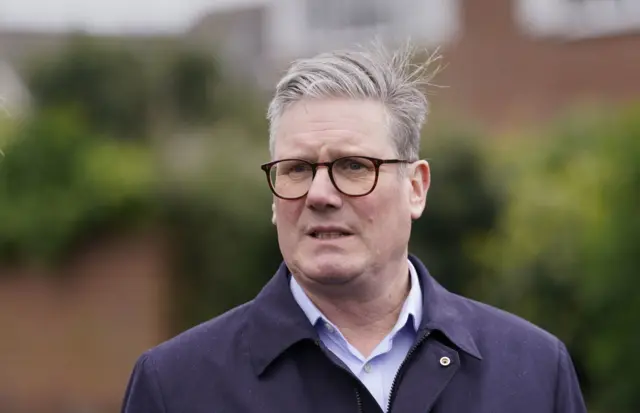 Sir Keir Starmer in a coat looking beyond the camera