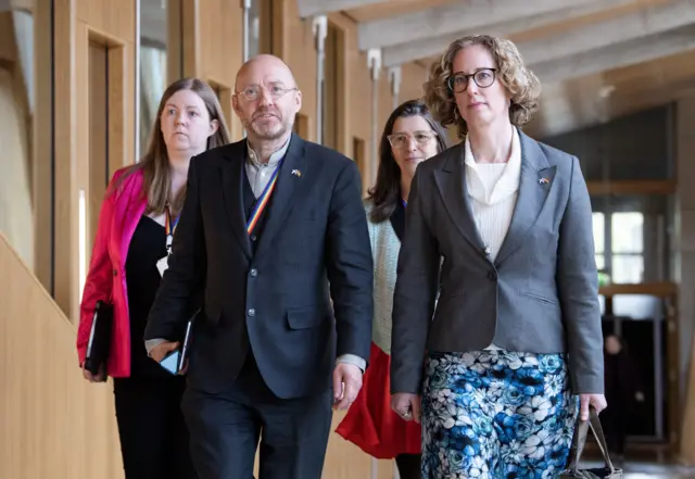 Scottish Green Party co-leaders Lorna Slater and Patrick Harvie walking down a corridor at the Scottish Parliament