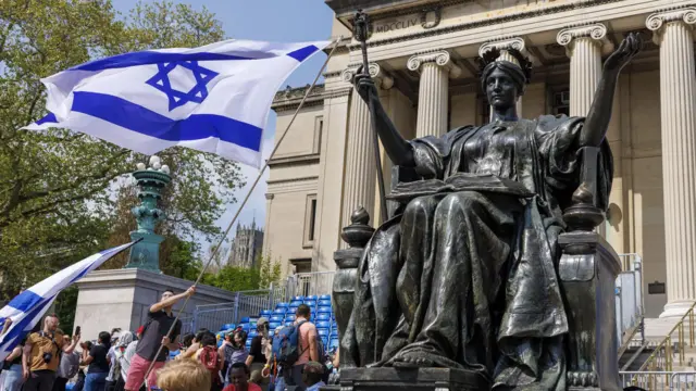 Demonstrator waving Israeli flag outside Columbia University