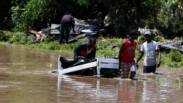 Residents carry a bed they salvaged from flood waters after Athi River burst its banks and marooned their homes following heavy rainfall in Kwa Mang'eli settlement of Machakos county near Nairobi, Kenya April 24